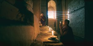 young-monks-praying-inside-a-dark-temple-in-bagan